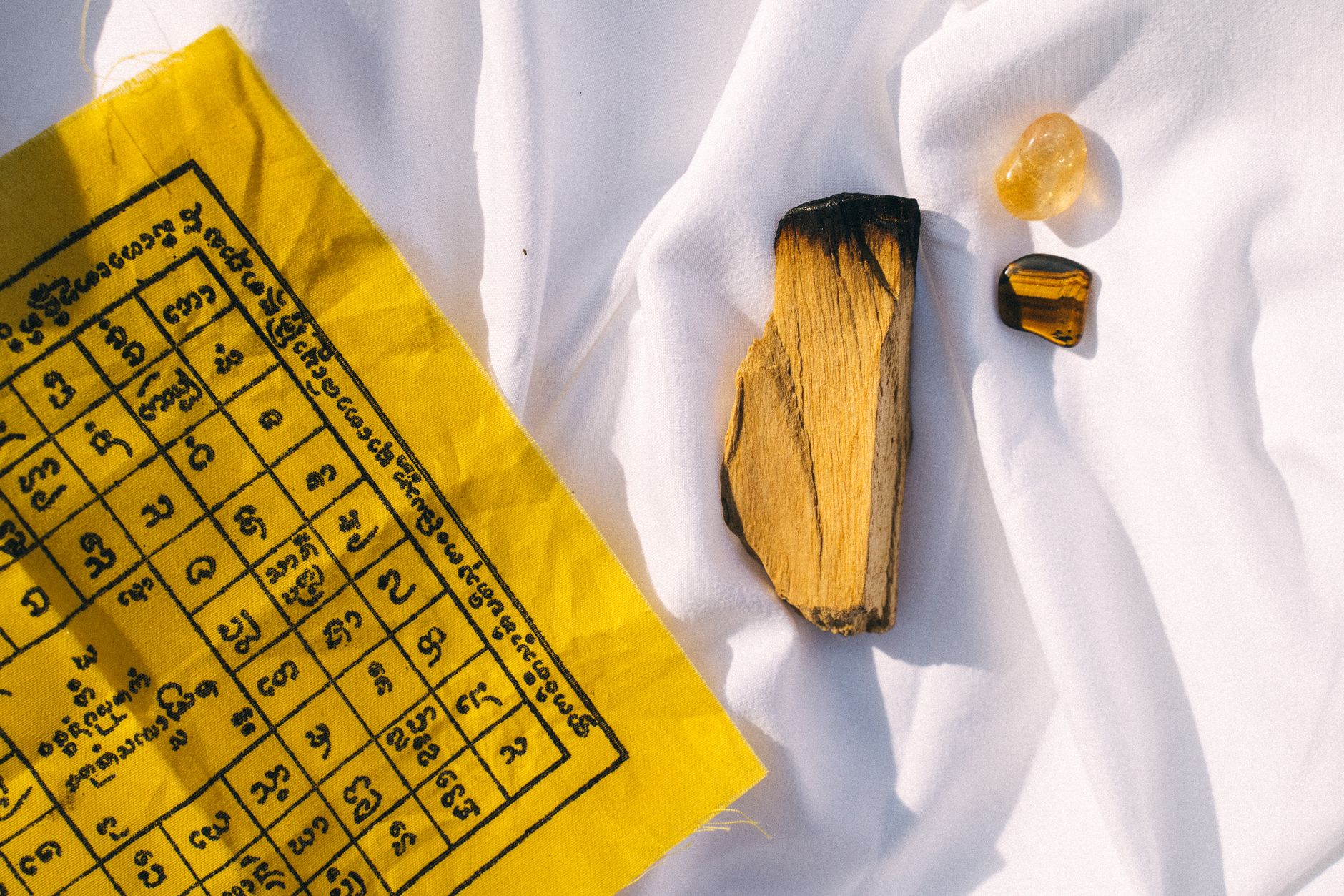Feathers, stones, and ceremonial items placed on a traditional Navajo weaving pattern.