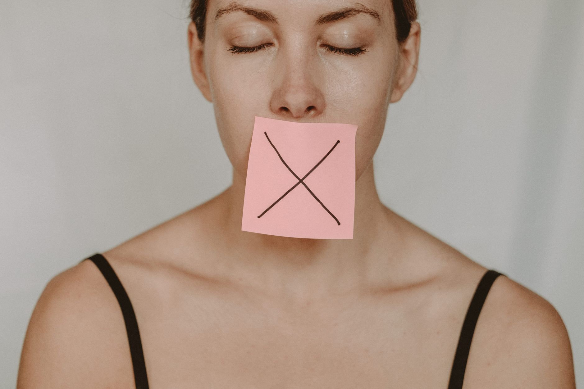 A person with mouth open mid-speech, surrounded by or emerging from dark, quiet emptiness.