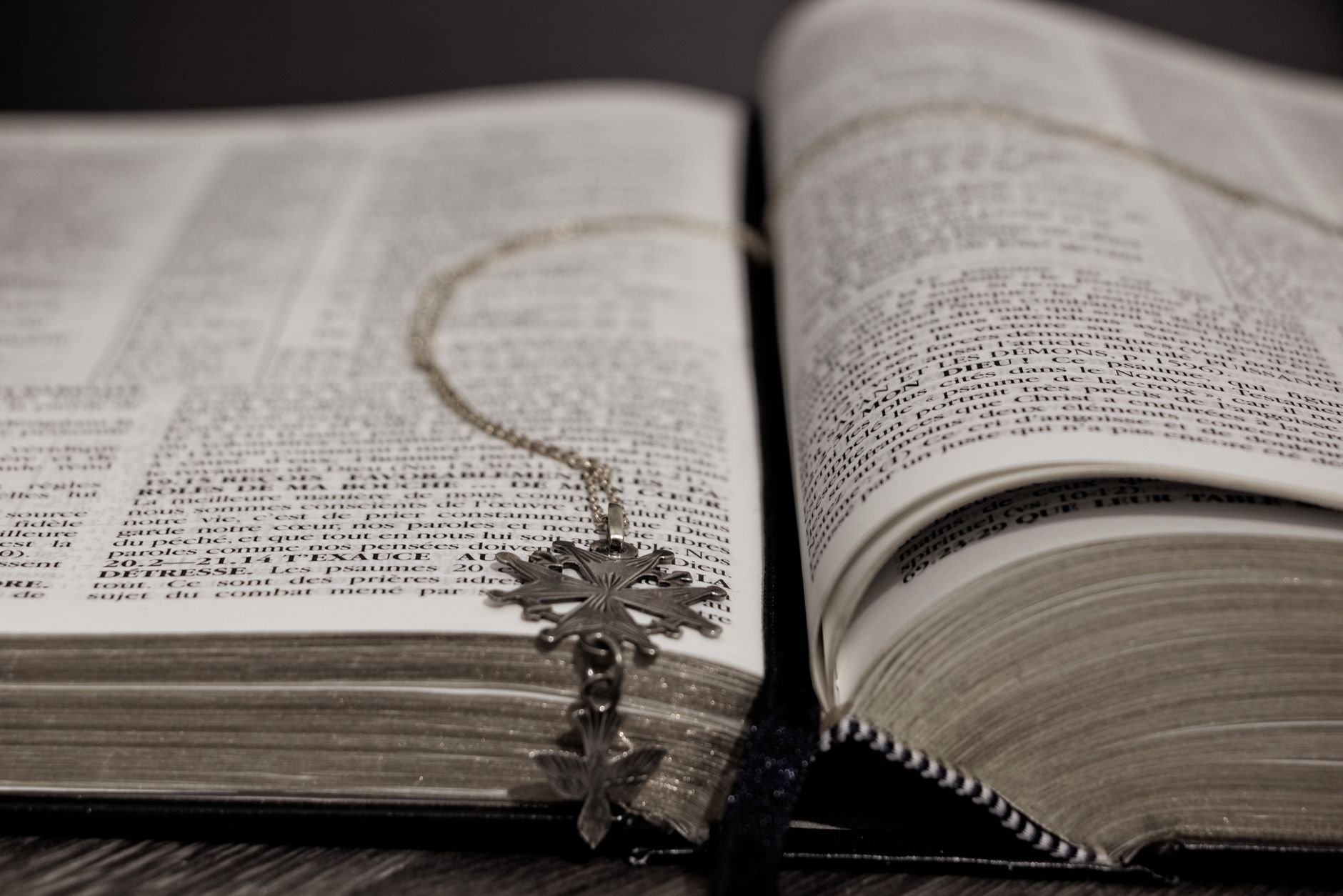 An open book surrounded by objects representing different spiritual traditions and belief systems.